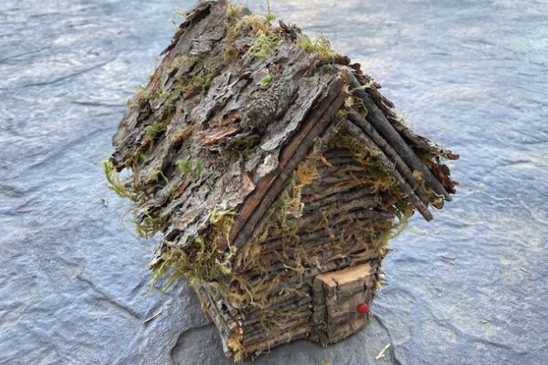 Log cabin fairy house made from twigs and bark