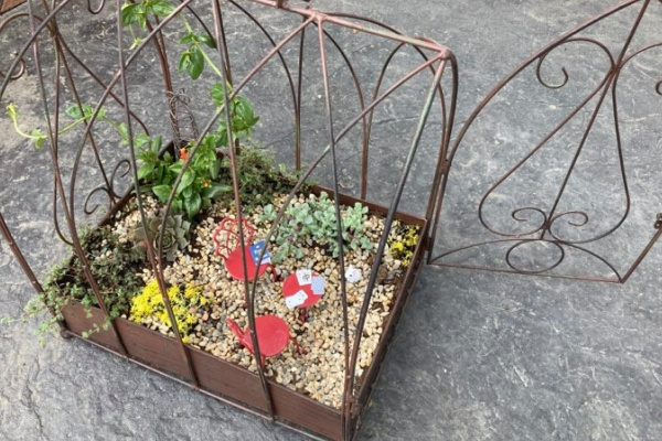 bird cage fairy garden with dollar store rocks in bottom