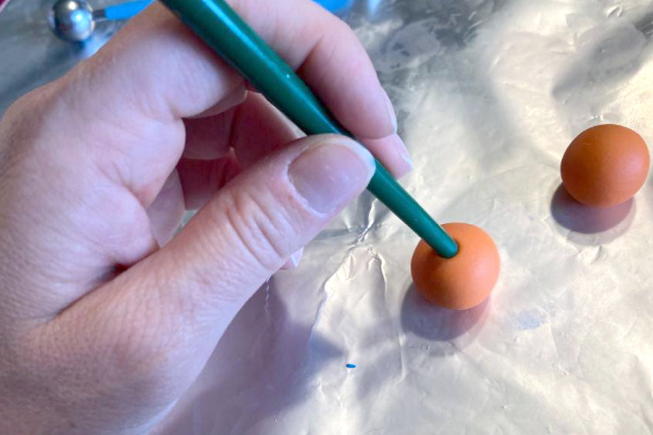 making an indent in the top of the orange ball (for the stem)