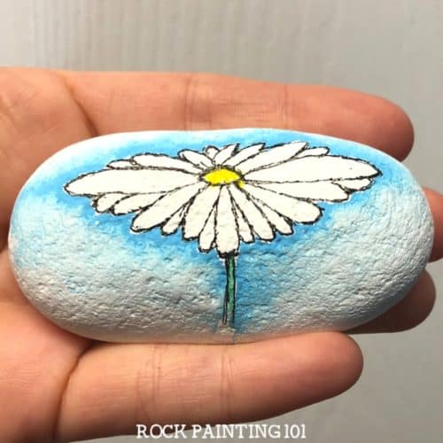 daisy flower painted on a rock