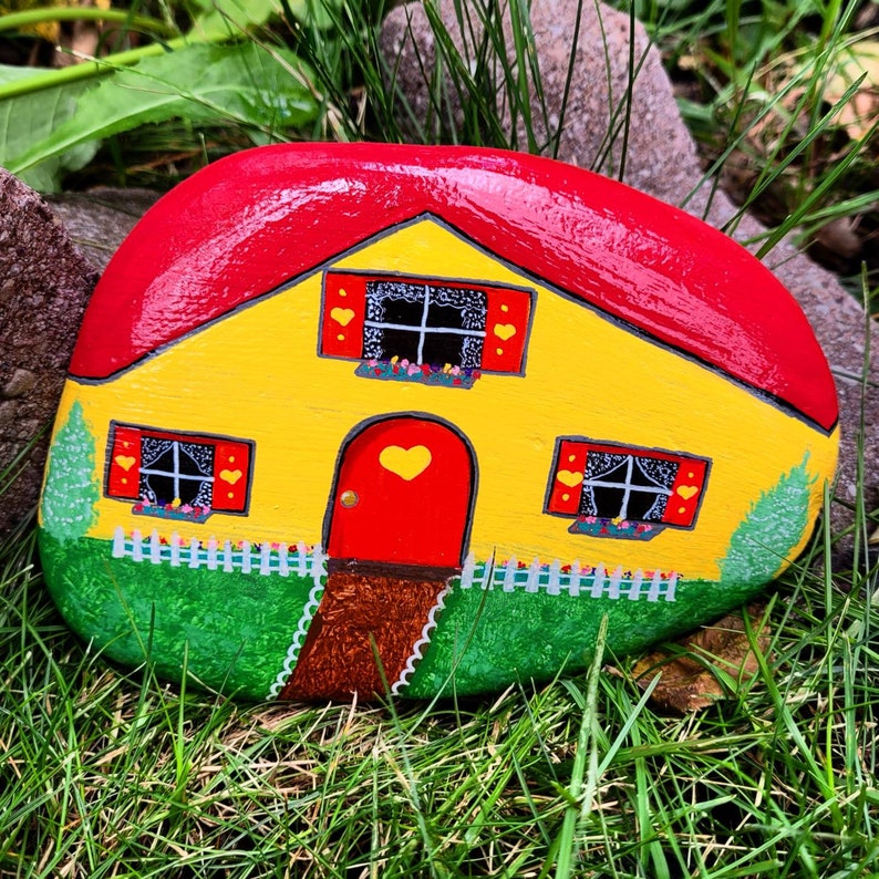 yellow fairy house painted on a rock