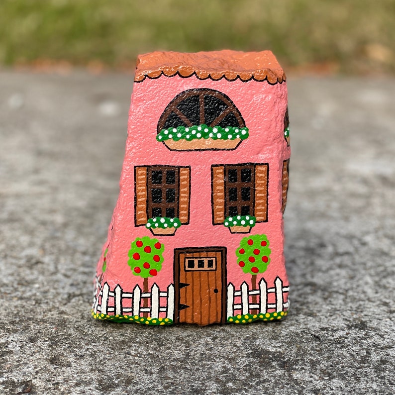 tall pink fairy house painted on a stone