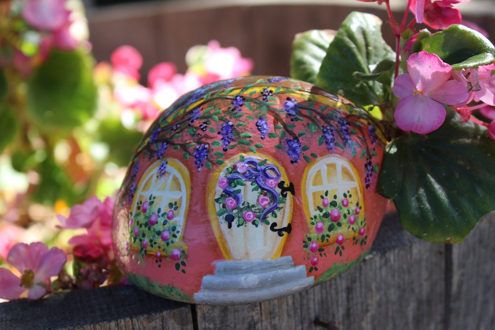 round stone painted fairy house with flowers