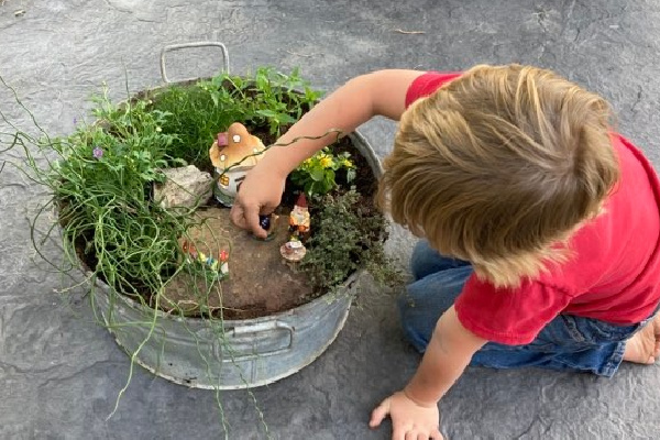 boy playing with a gnome garden